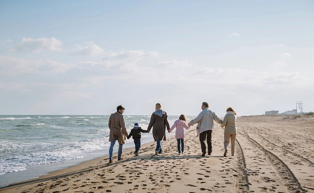 A happy family walking on a beach.