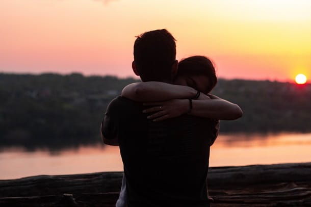 Two people hugging during a sunset.