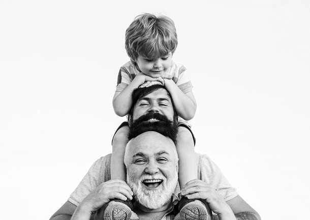 Three generations of men laughing while looking into the camera.