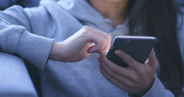 Woman using her phone at night.