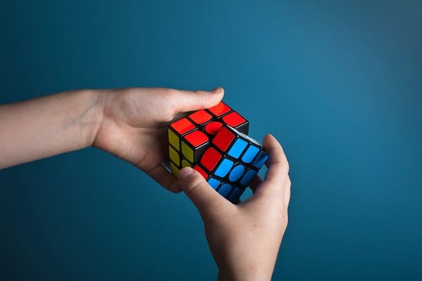 Two hands trying a to solve a Rubik's cube.