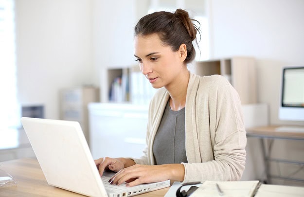 A focused woman working on her laptop.