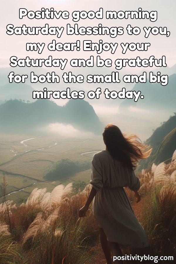 A woman looking down into a valley in the morning.