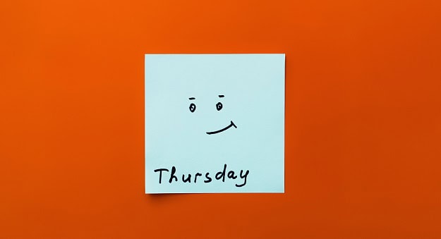 A post it with a half smiling smiley and the word Thursday.