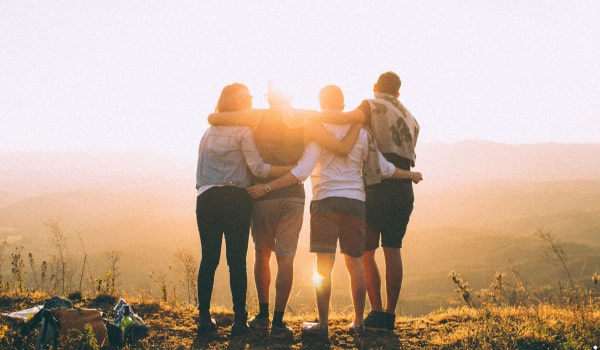 Friends hugging and watching a sunset.