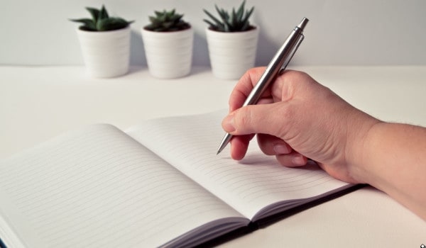 A man writing in a notebook.