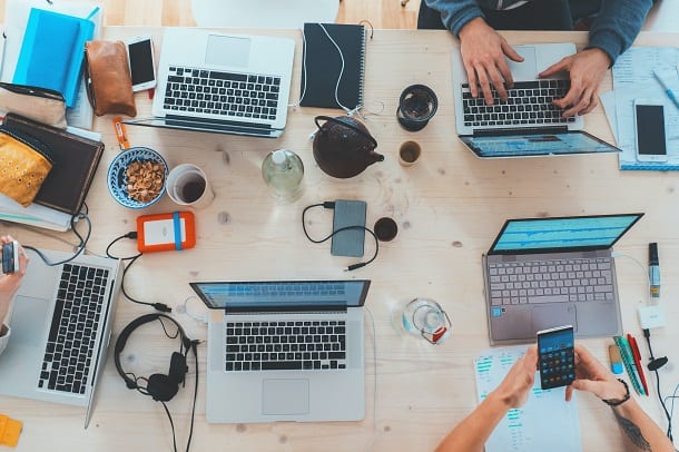 Image of people around a table working at their computers.