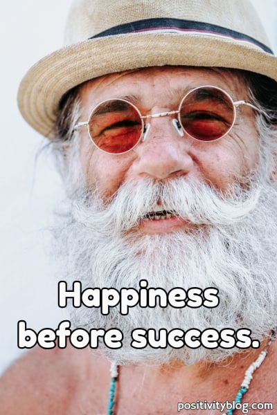A man enjoying his day with the quote: happiness before success.