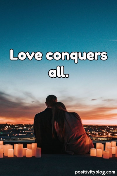 A loving couple looking out over the sunset.