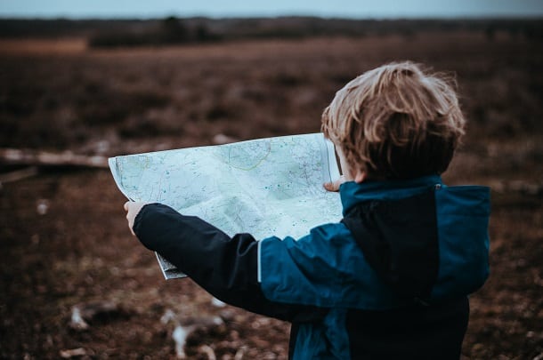 An image of a boy holding a map.