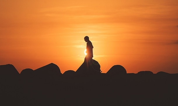A man walking during sunset.